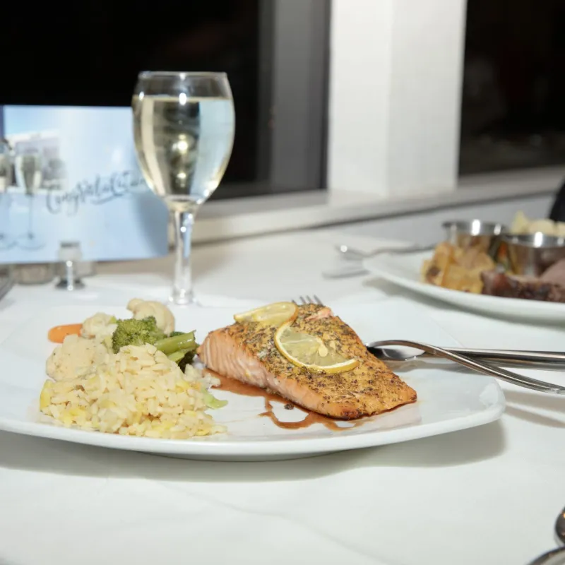 a plate of food and glasses of wine on a table