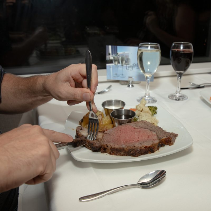 a man holding a plate of food on a table
