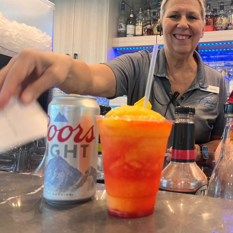 a person sitting at a table with a glass of orange juice
