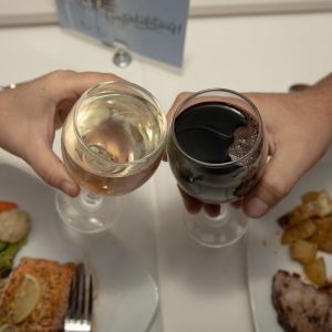 a person holding a plate of food on a table