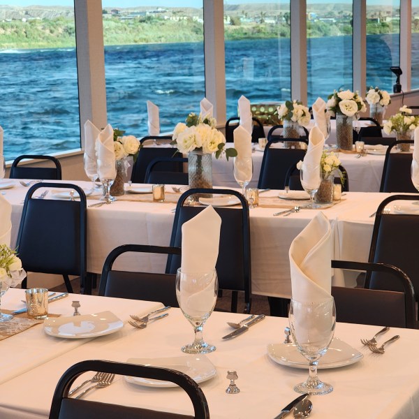 a group of people sitting at a table in front of water